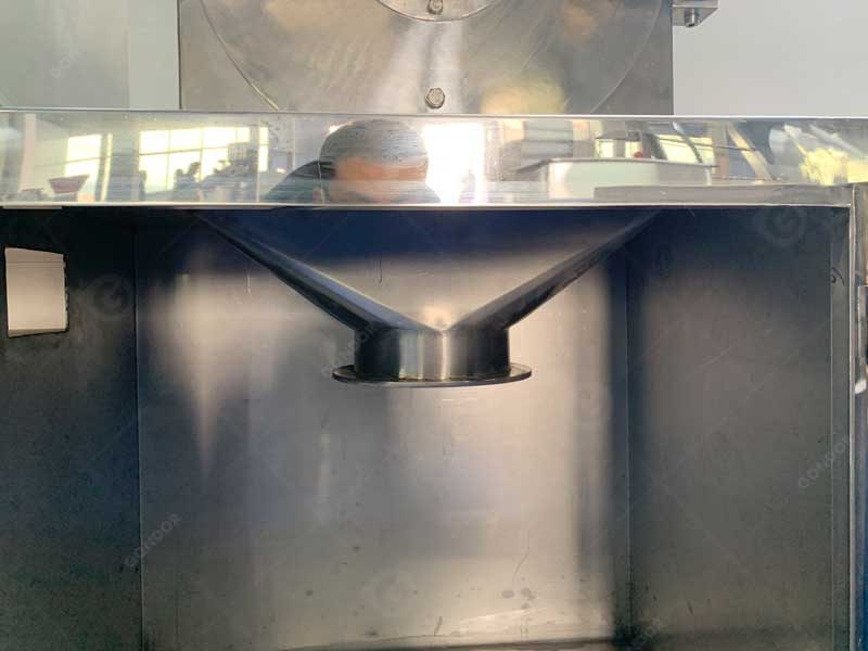 Internal discharge funnel inside a stainless steel powder grinder cabinet