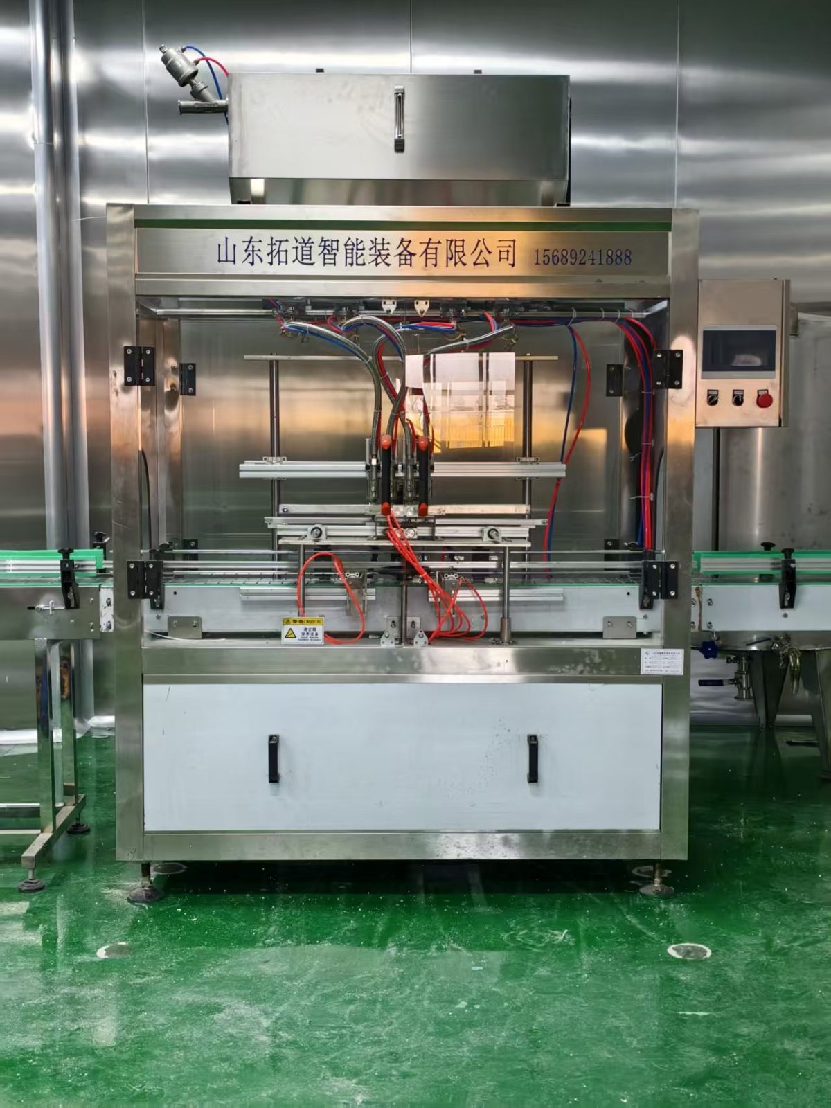 Automatic multi-head edible oil filling machine installed on a bottle conveyor