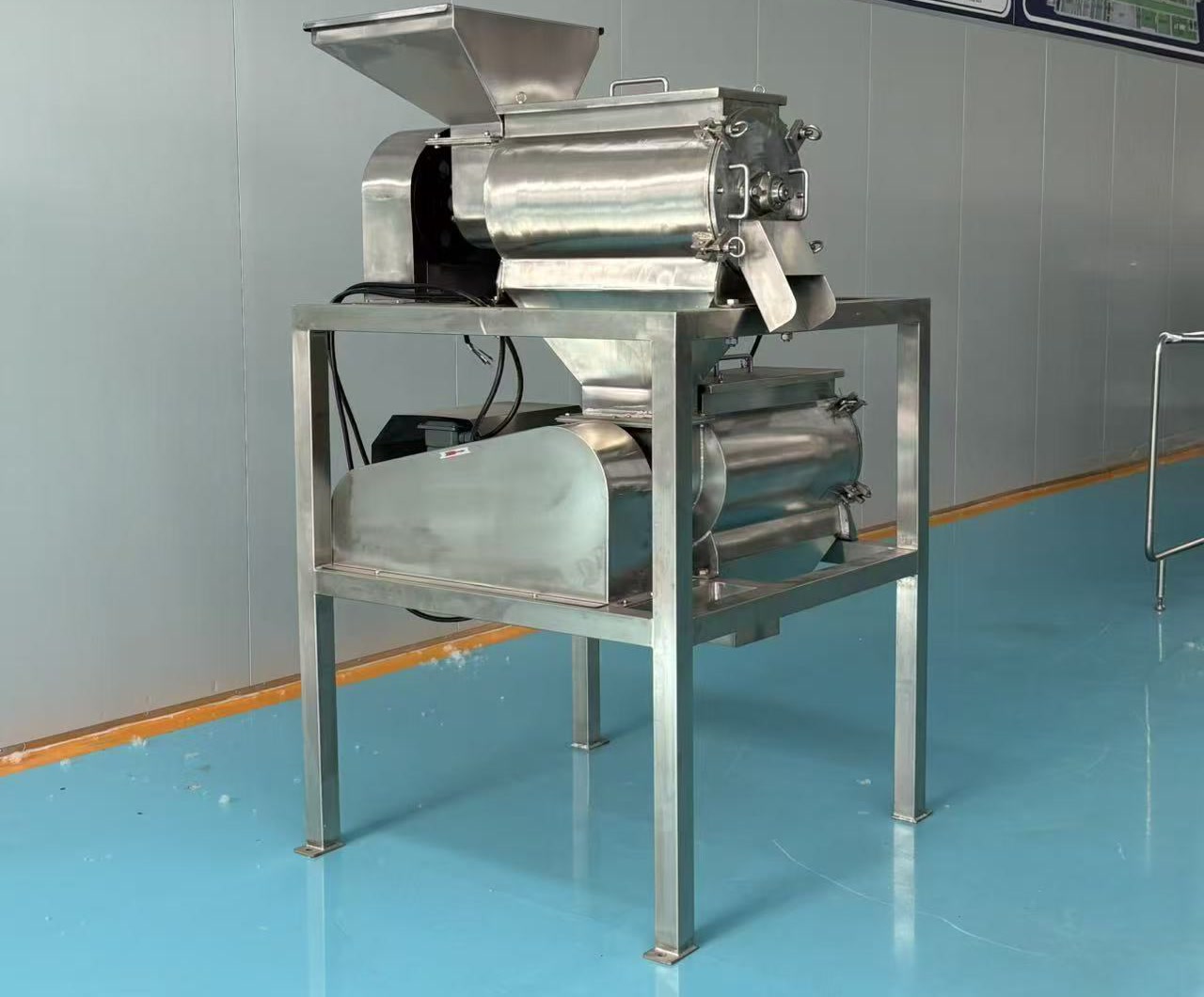 Rear view of a double-stage avocado pit removal and pulping machine