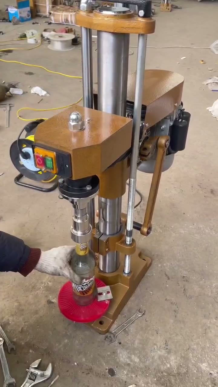 TY-4 semi-automatic aluminium cap sealing machine with operator placing a bottle on the red bottle-support plate